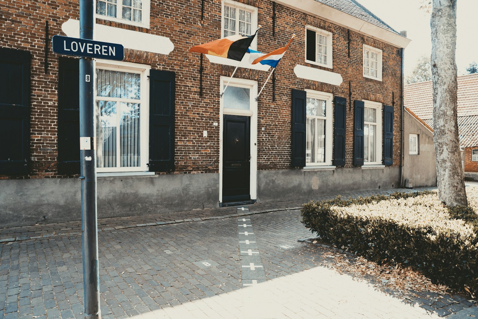Grenslijn tussen Baarle-Nassau en Baarle-Hertog voor een huis met de Nederlandse en Belgische vlag